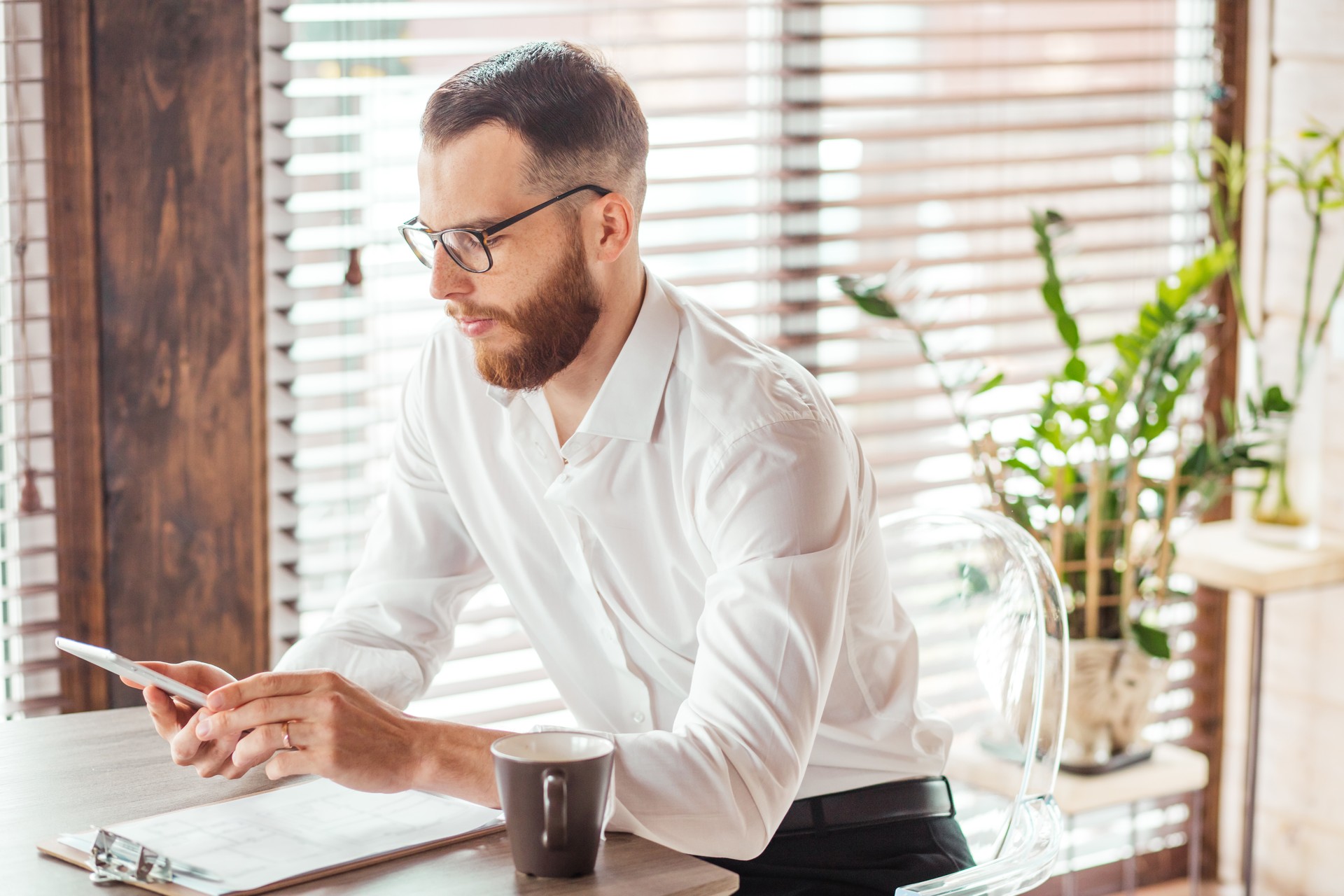 Serious applicant sitting in boardroom, preparing for interview with employer.